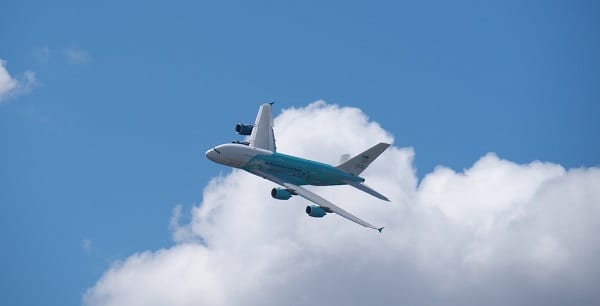 an airplane flying in blue sky with clouds